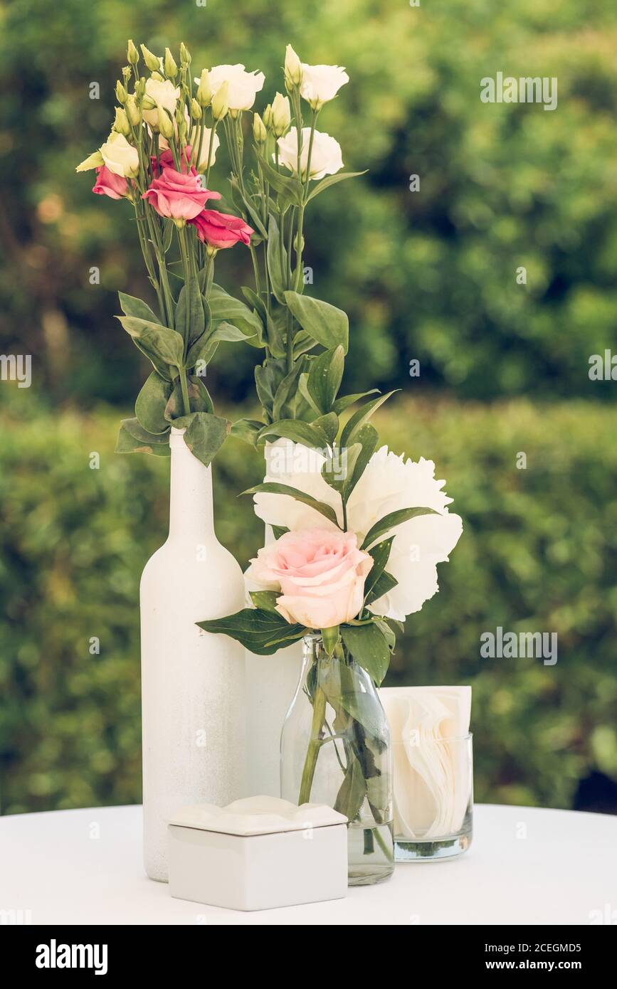 Delicate flowers in vases and bottles Stock Photo