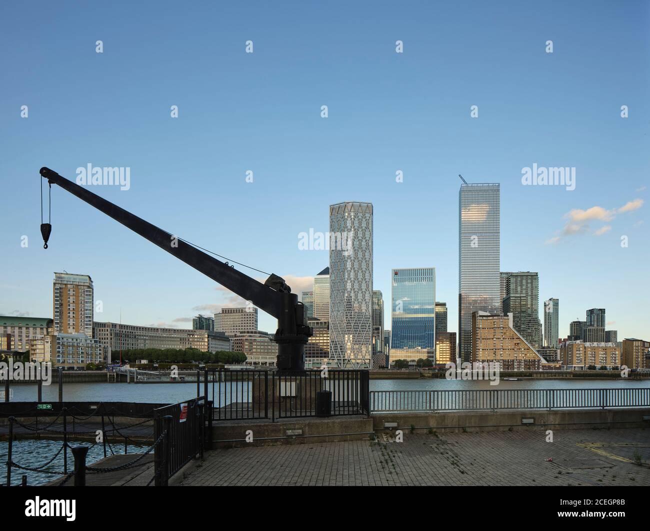View across river with historic crane in foreground. Newfoundland Tower, London, United Kingdom. Architect: Horden Cherry Lee Architects Ltd, 2020. Stock Photo