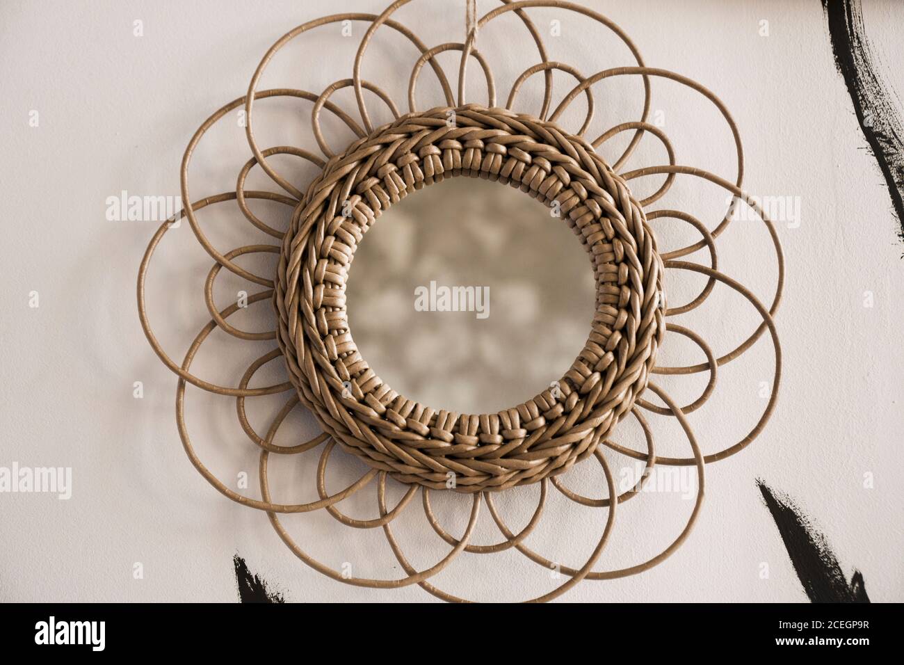 Vintage rattan mirrors on white textured wall. Round mirror with frame