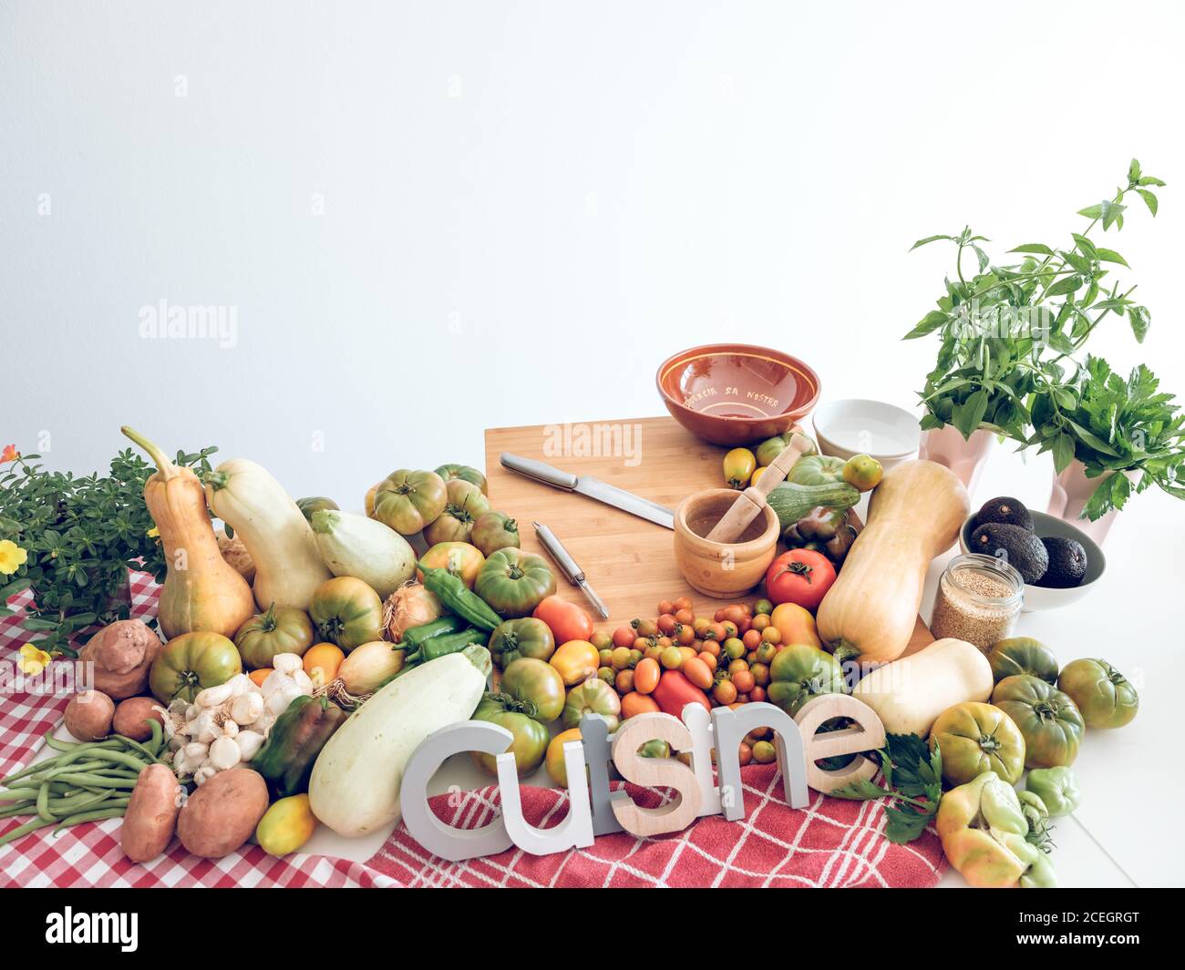Set of different fresh harvested vegetables and Cuisine word on a table ...