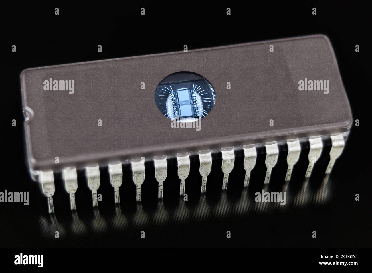 Erasable programmable read-only memory. Digital integrated circuit die with thin silver wires. DIP package with transparent window to UV erase of data. Stock Photo