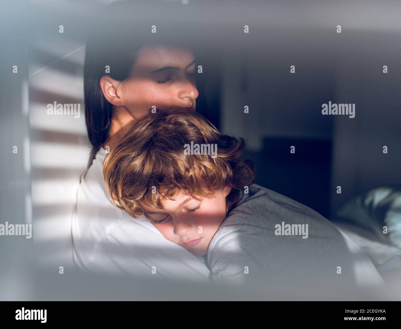 Adorable boy lying on napping Woman and peacefully sleeping while spending time together. Stock Photo