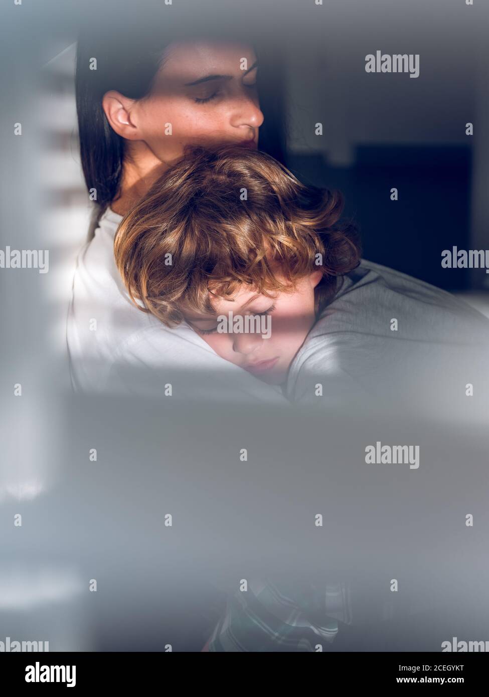 Adorable boy lying on napping Woman and peacefully sleeping while spending time together. Stock Photo