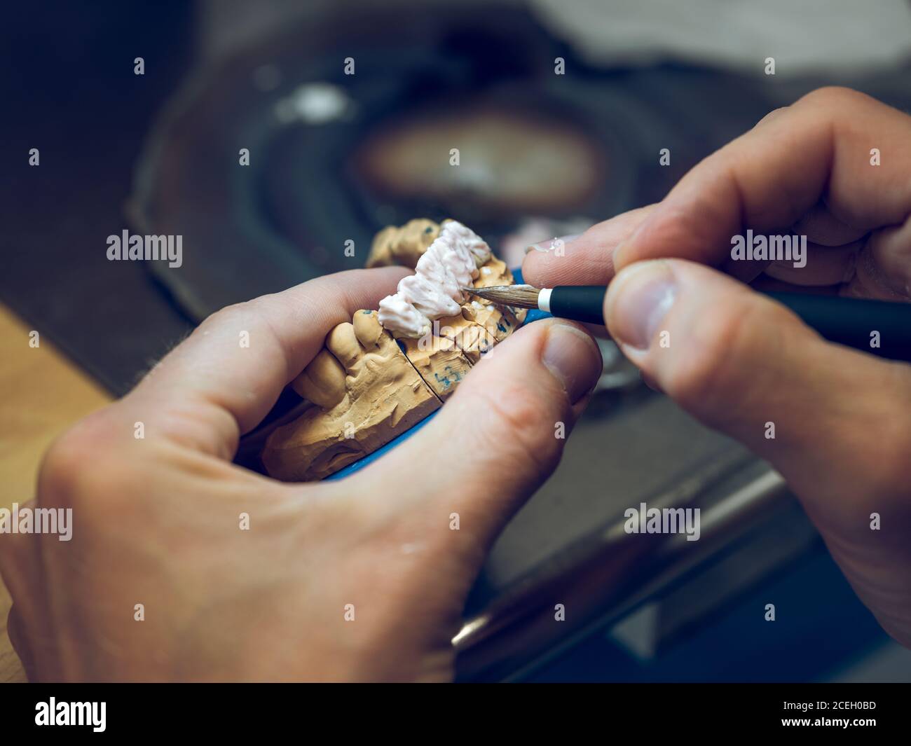Crop man applying enamel on mold Stock Photo