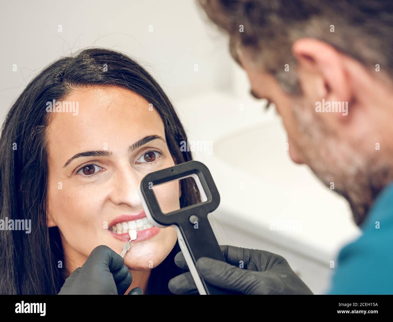 unrecognizable dentist looking through magnifying glass and trying ...