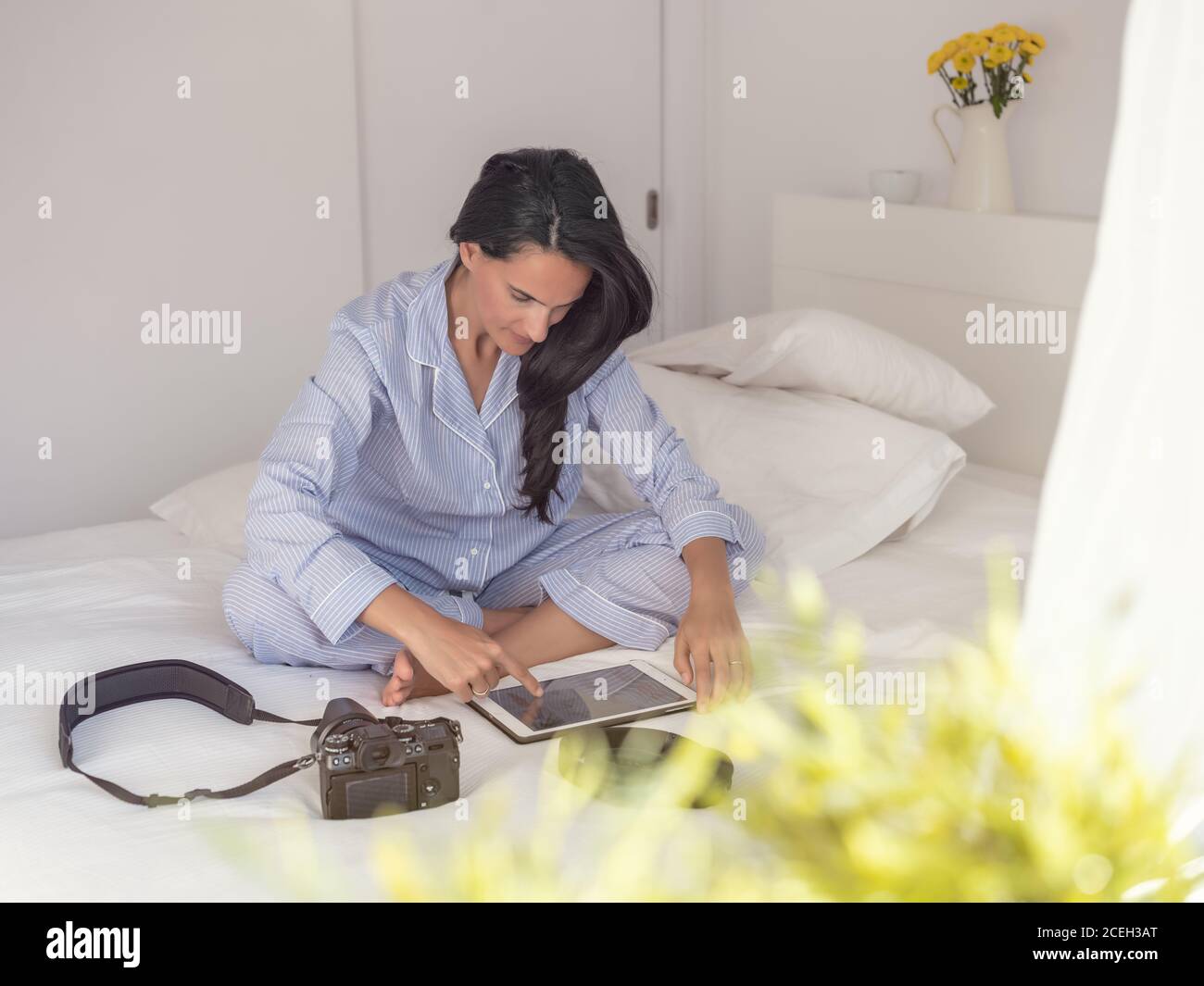 Young Woman sitting on bed Stock Photo