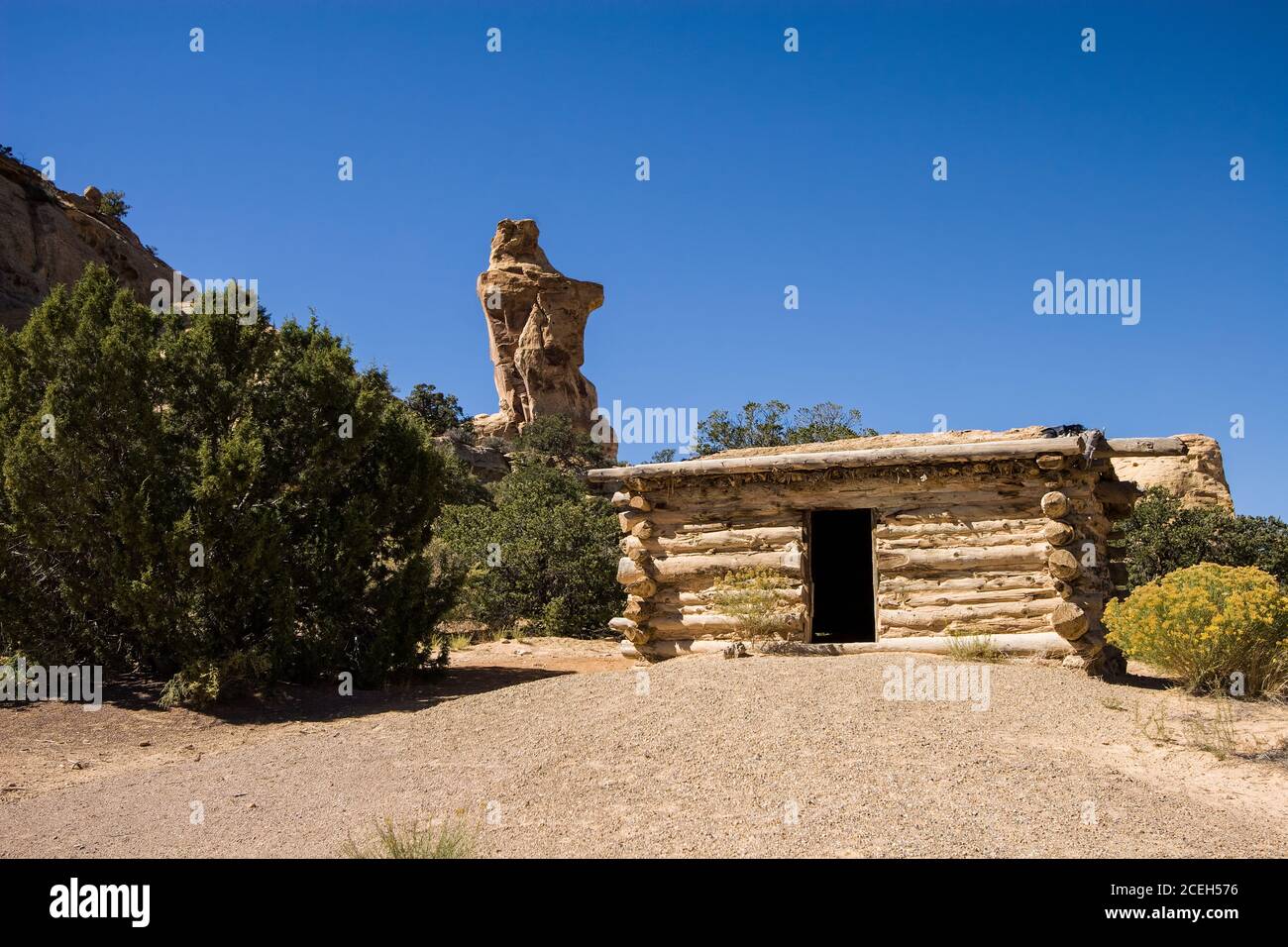 The Swasey's Cabin was built in 1921 as a shelter for cowboys working on a ranch on the San Rafael Swell in central Utah.  Broken Cross Tower rises be Stock Photo