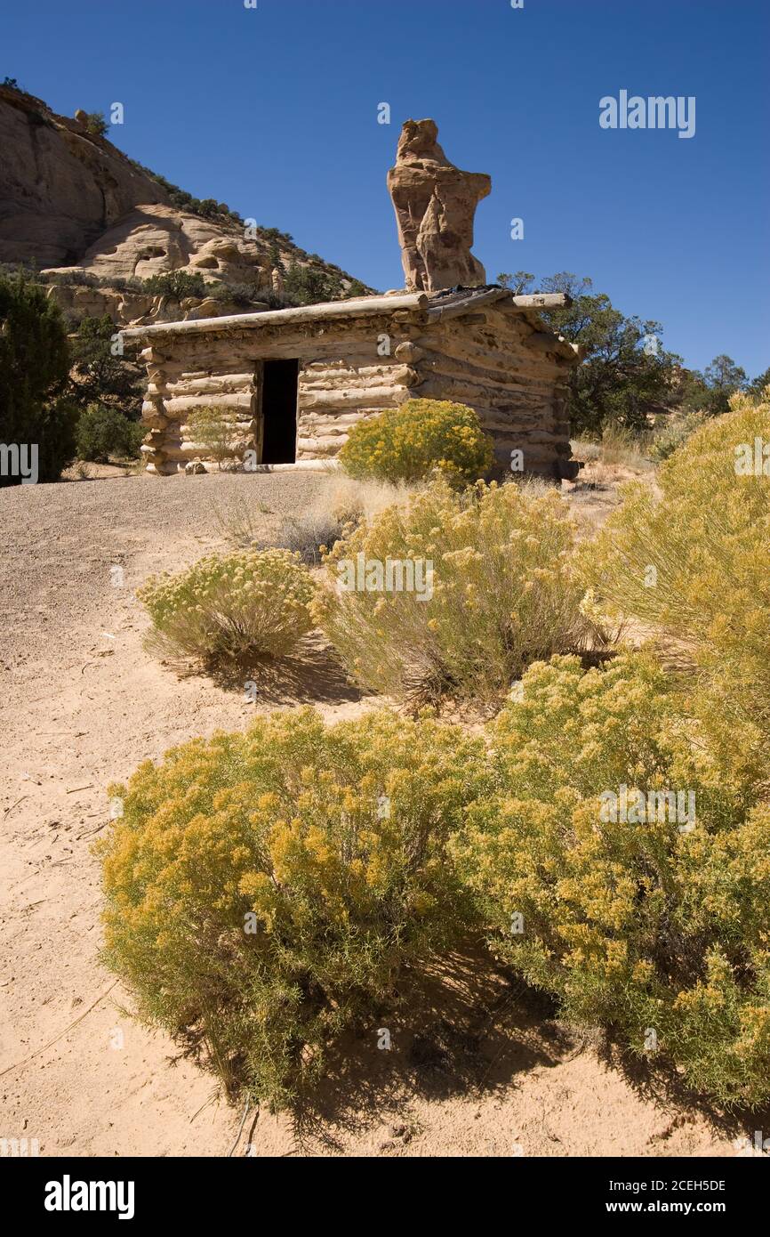 The Swasey's Cabin was built in 1921 as a shelter for cowboys working on a ranch on the San Rafael Swell in central Utah.  Broken Cross Tower rises be Stock Photo