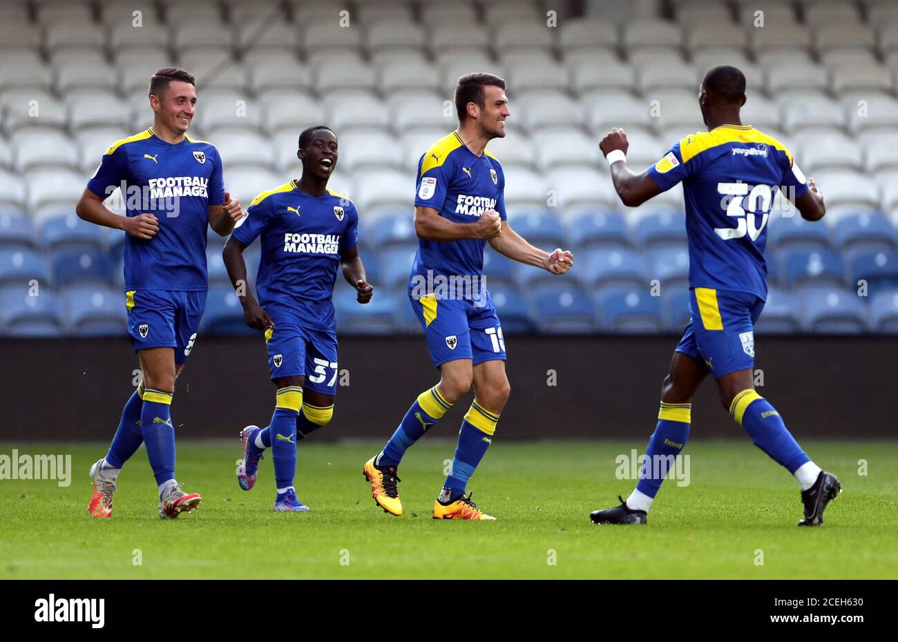 AFC Wimbledon's Adam Roscrow (centre) celebrates scoring his side's first goal of the game with team-mates during the EFL Trophy, Southern Group G match at The Kiyan Prince Foundation Stadium, London. Stock Photo