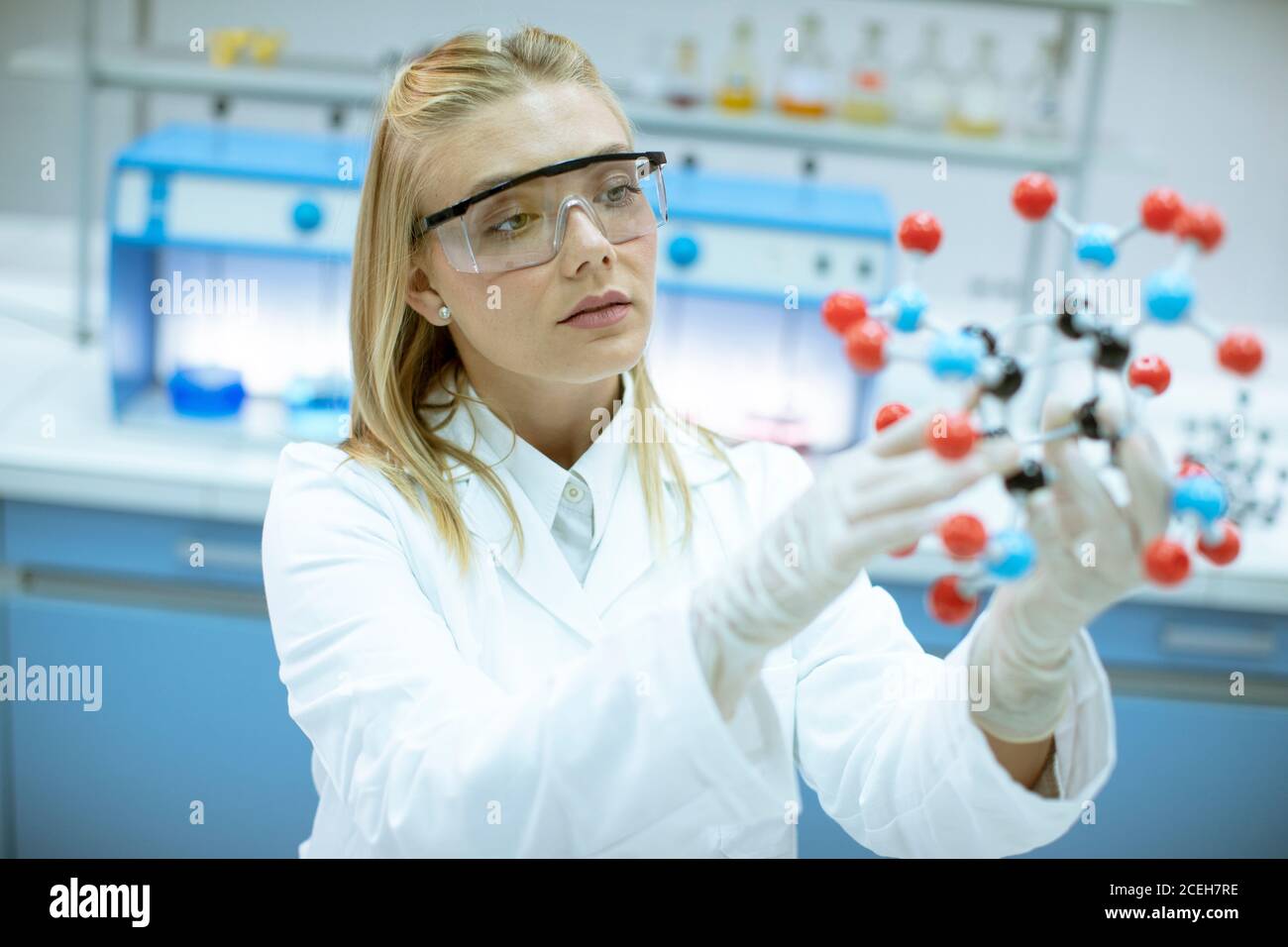 Female chemist with safety goggles hold molecular model in the lab Stock Photo Alamy