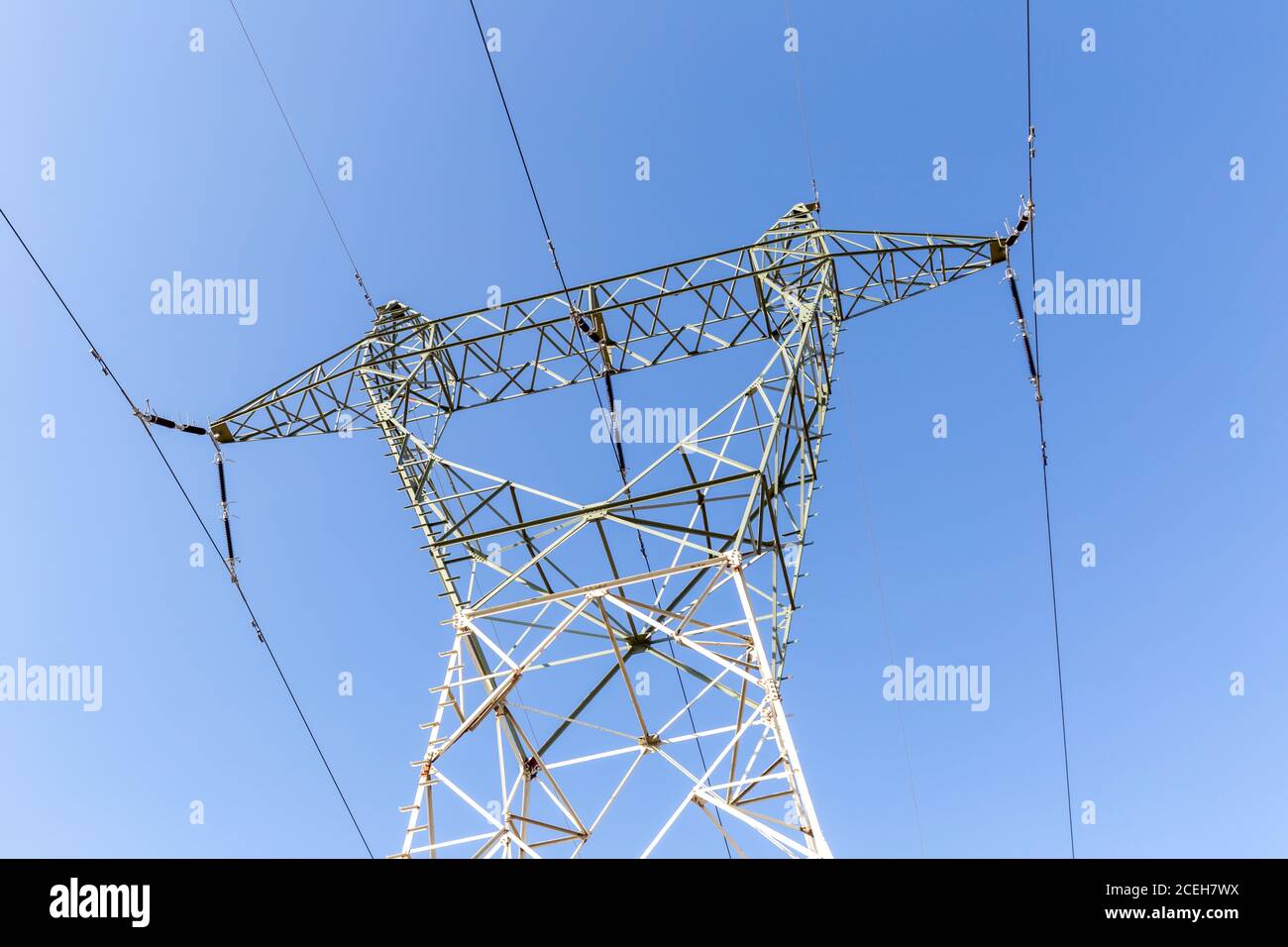 High voltage, electricity tower under blue sky Stock Photo - Alamy