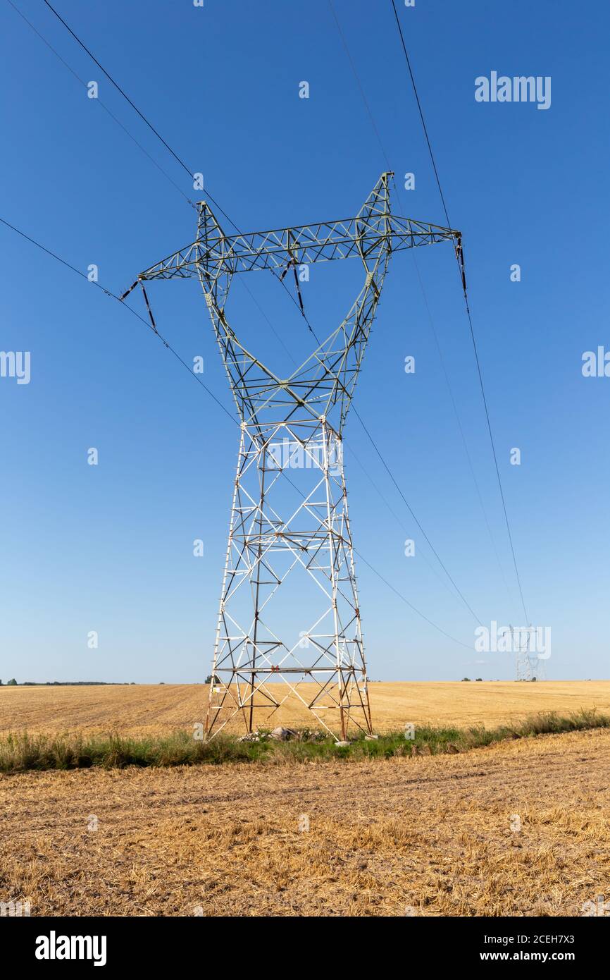 High voltage, electricity tower under blue sky Stock Photo - Alamy