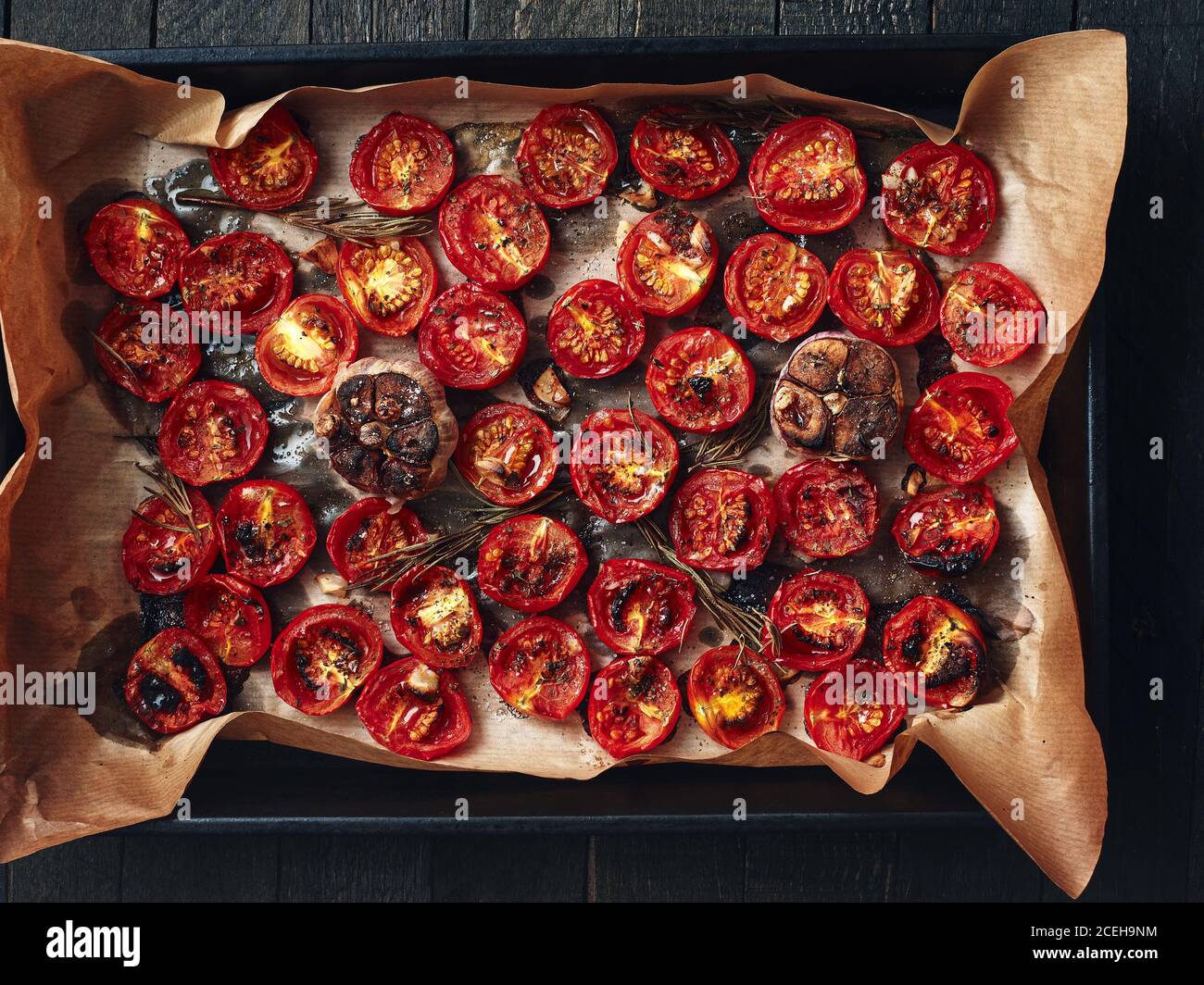 Oven roasted cherry tomatoes on an oven tray. Overhead view. Stock Photo