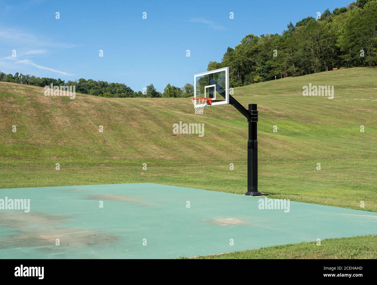 Empty court for basketball or netball in state park surrounded by hills and trees in the distance. No people. Stock Photo