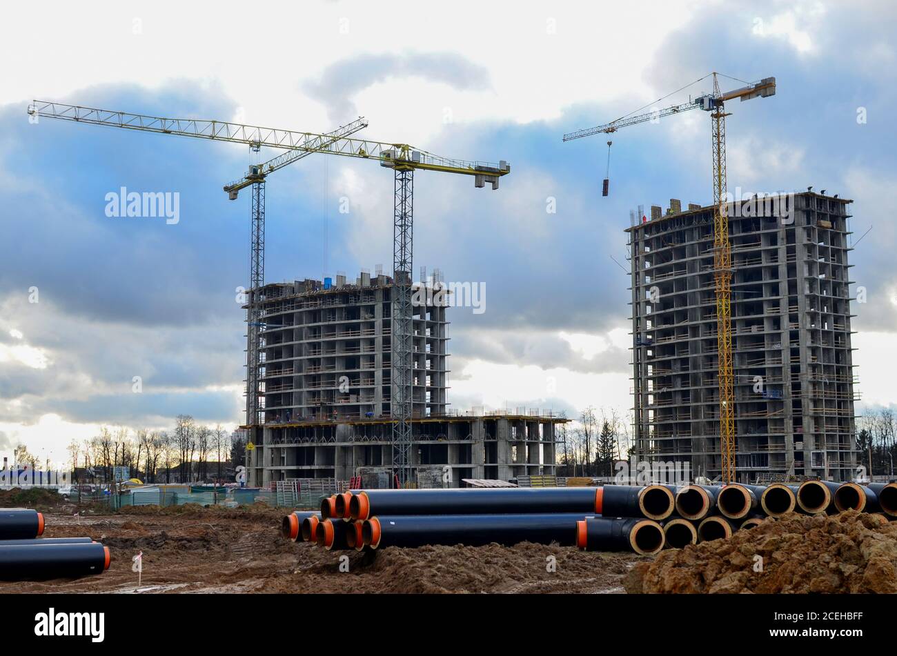 The drainage pipes at the large scale construction site against tower cranes and blue sky