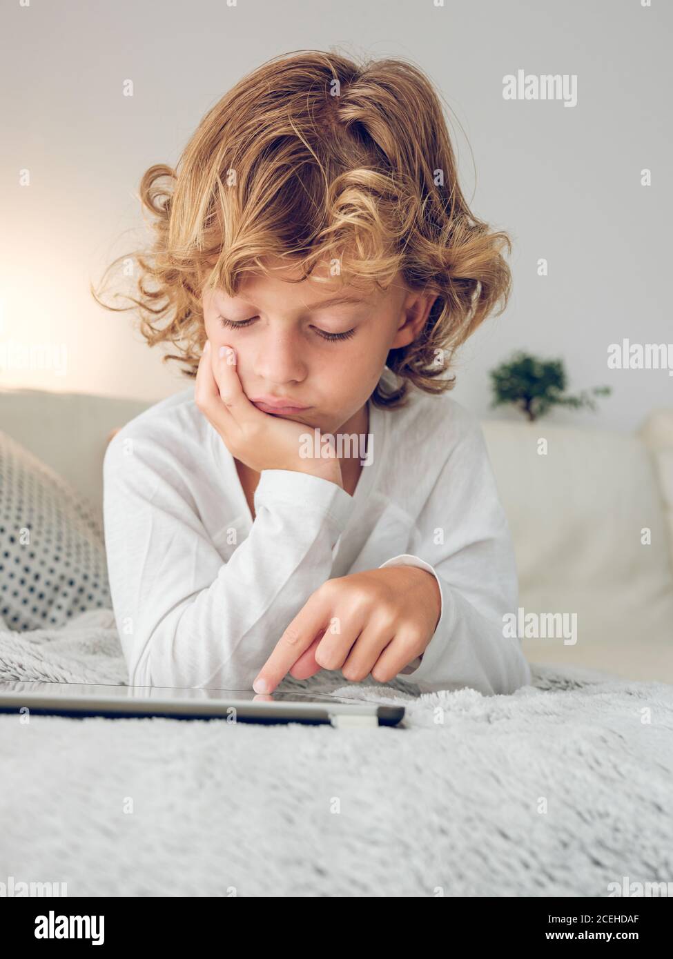 Cheerful boy using tablet of couch Stock Photo