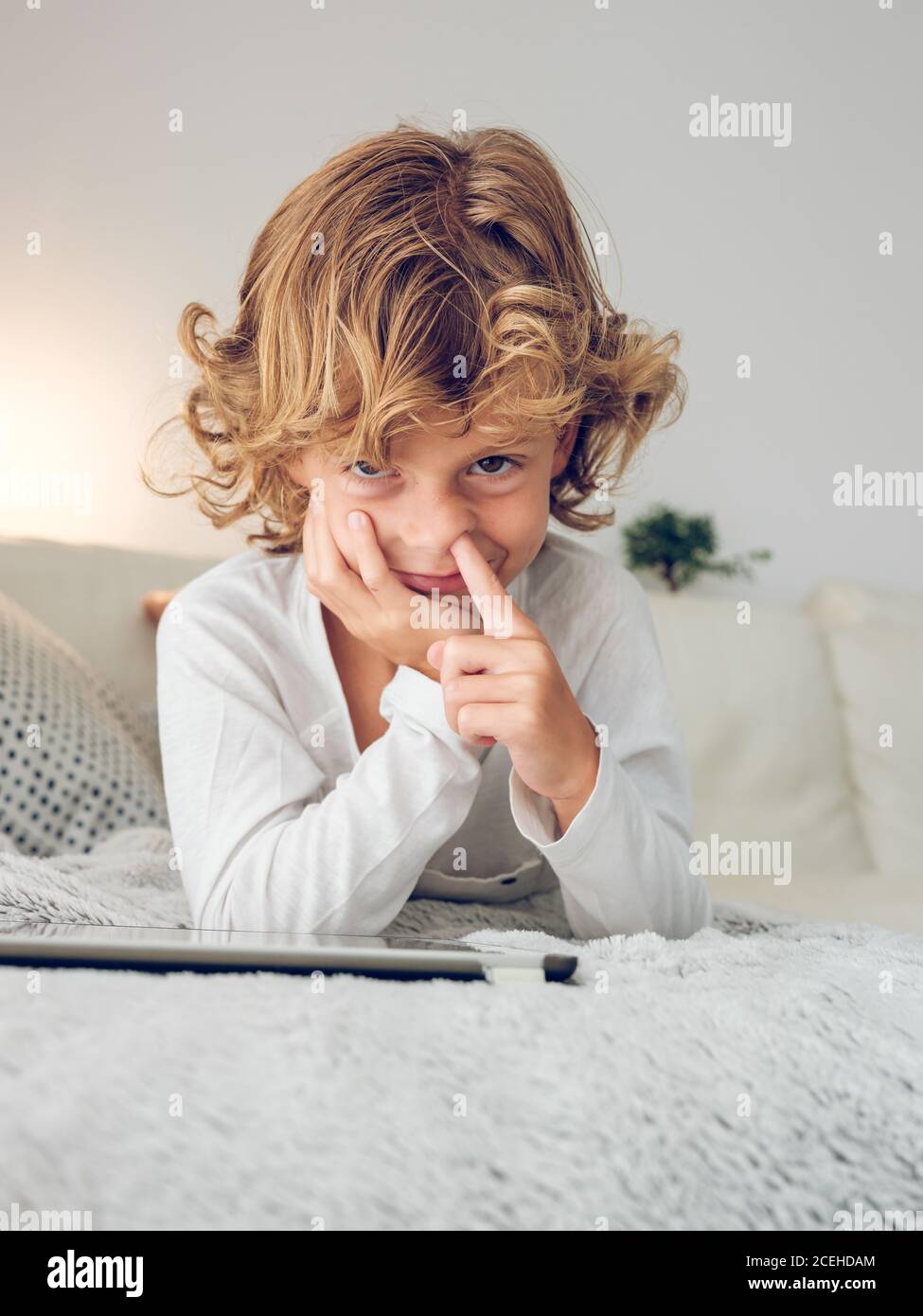 Cheerful boy using tablet of couch Stock Photo