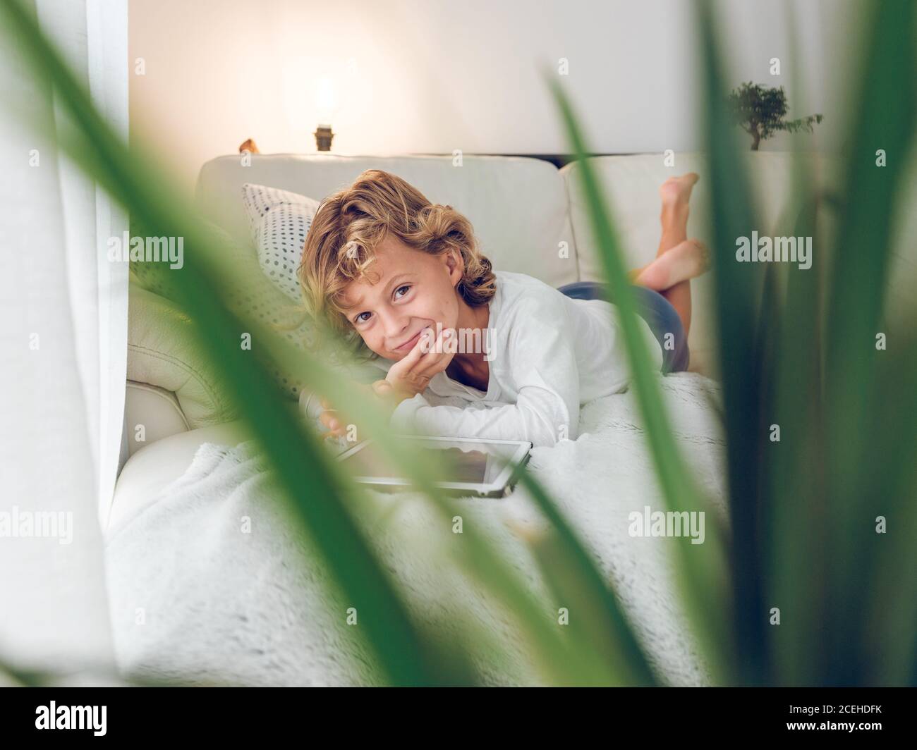 boy using tablet on sofa Stock Photo