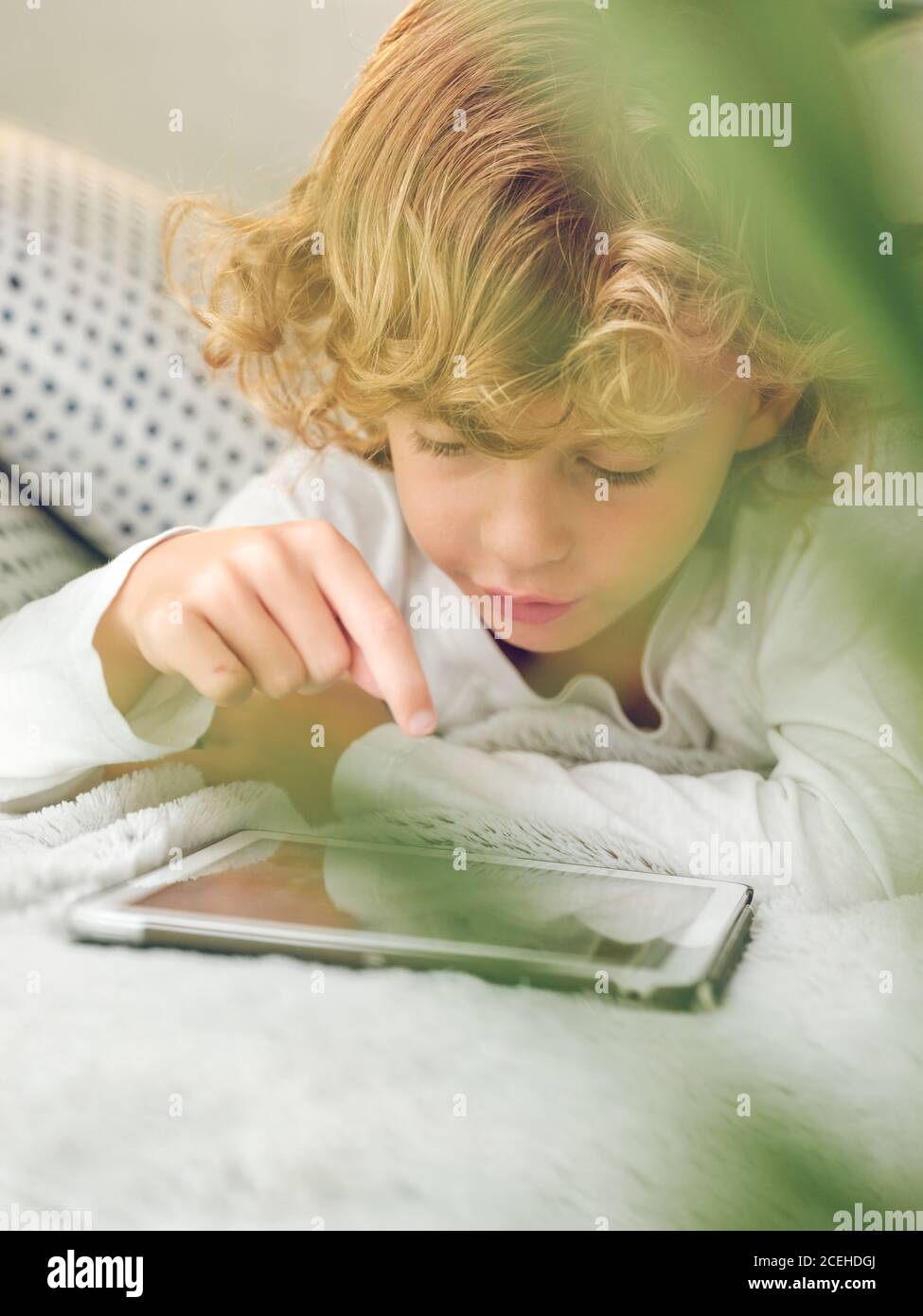 boy using tablet on sofa Stock Photo