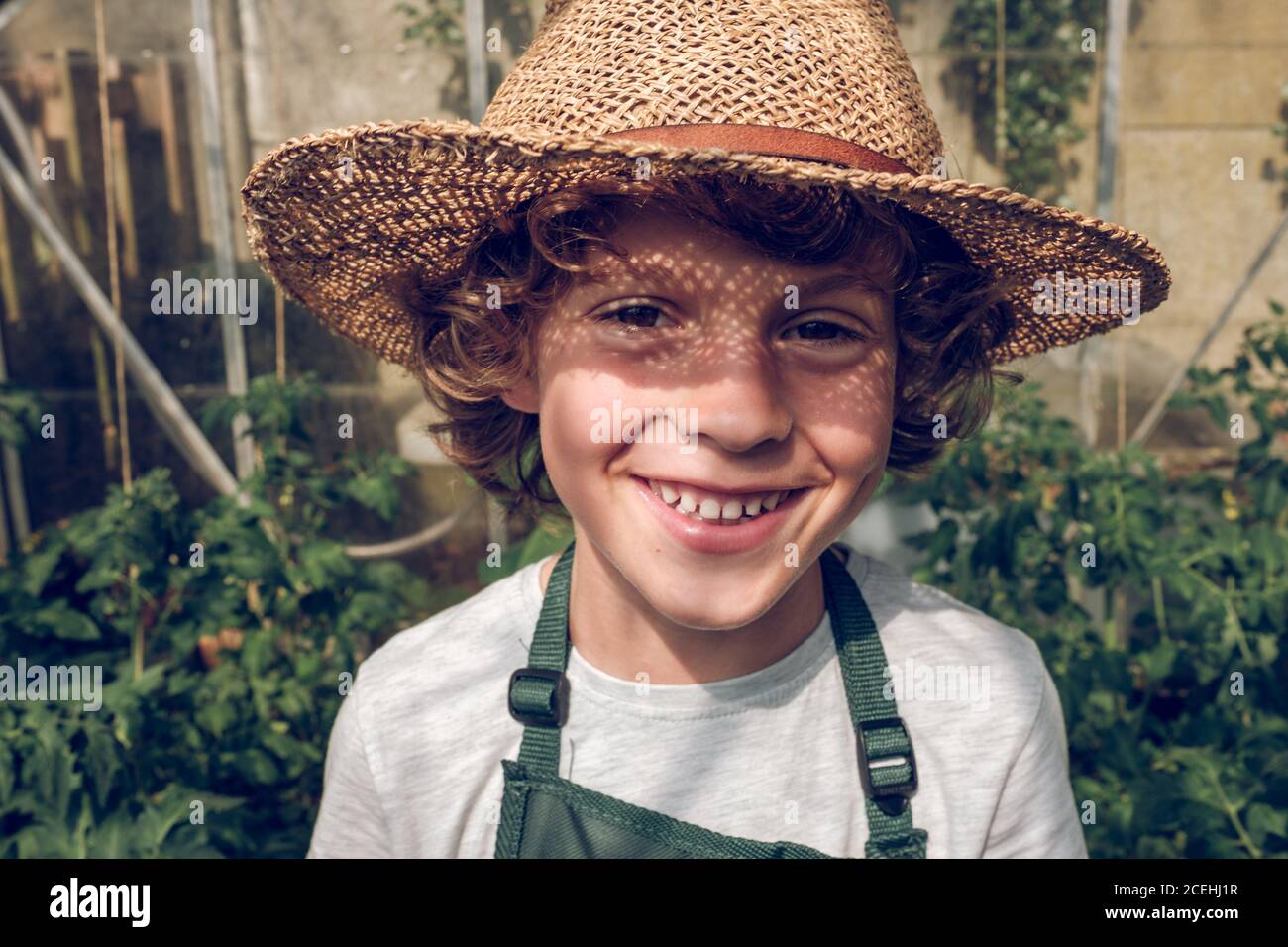 curls wearing straw hat and laughing 