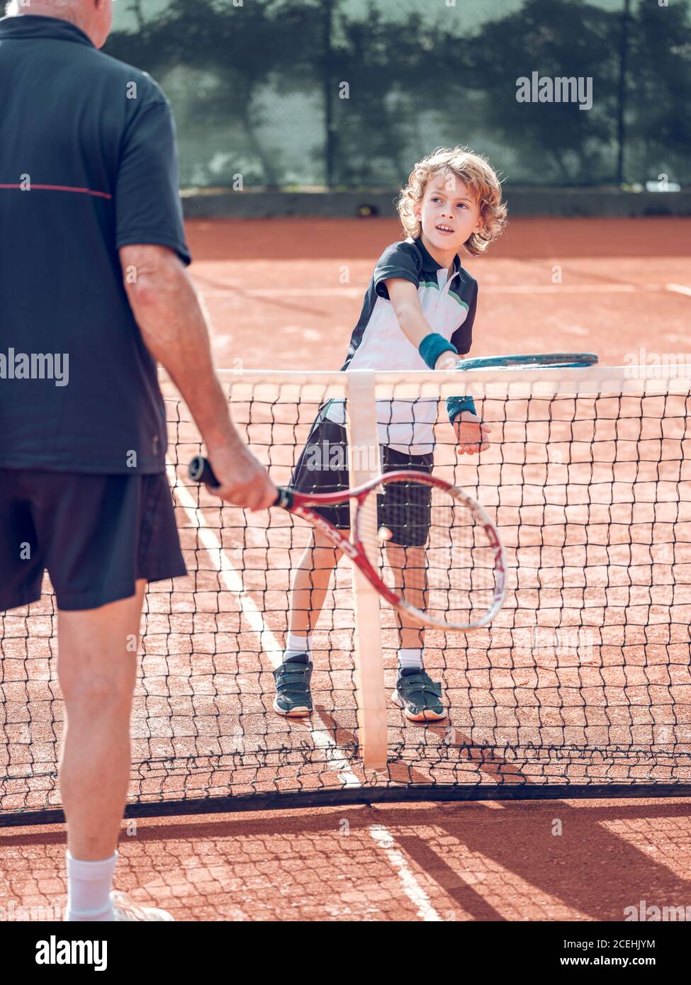 Little Tennis Rackets Back view crop aged male and little child with tennis rackets near ...