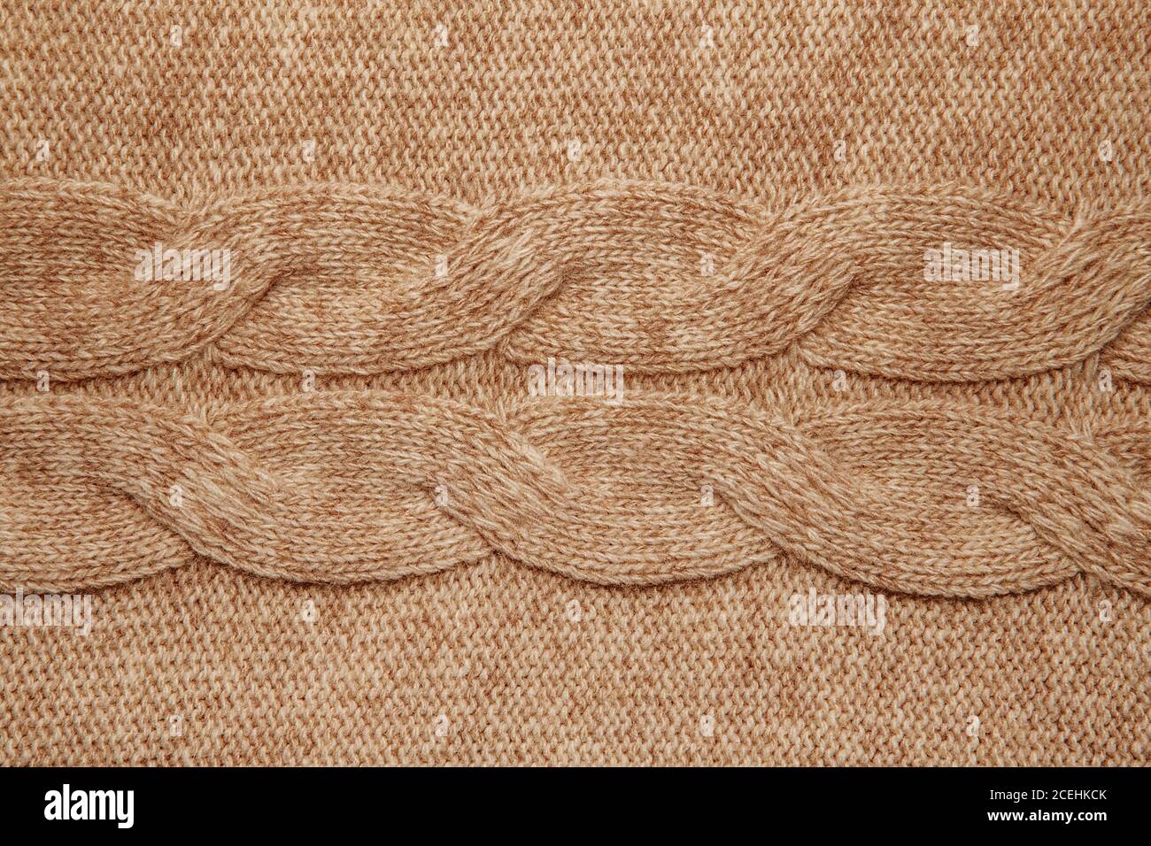 Wool sweater texture close up. Knitted jersey background with a relief pattern. Braids in machine knitting pattern Stock Photo