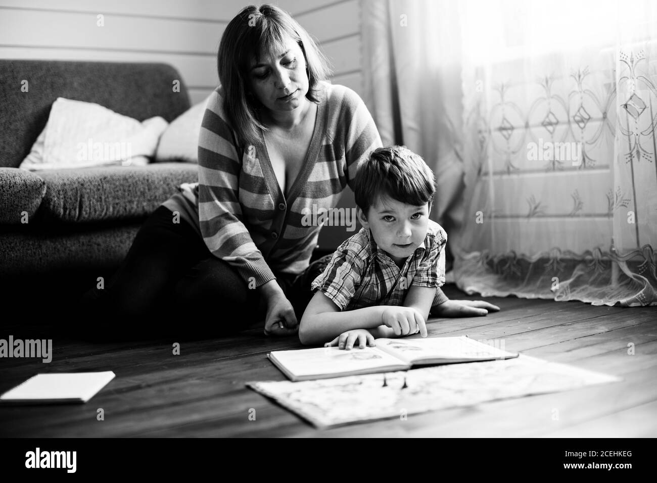 Mother is engaged in training young son. Black and white photography. Stock Photo
