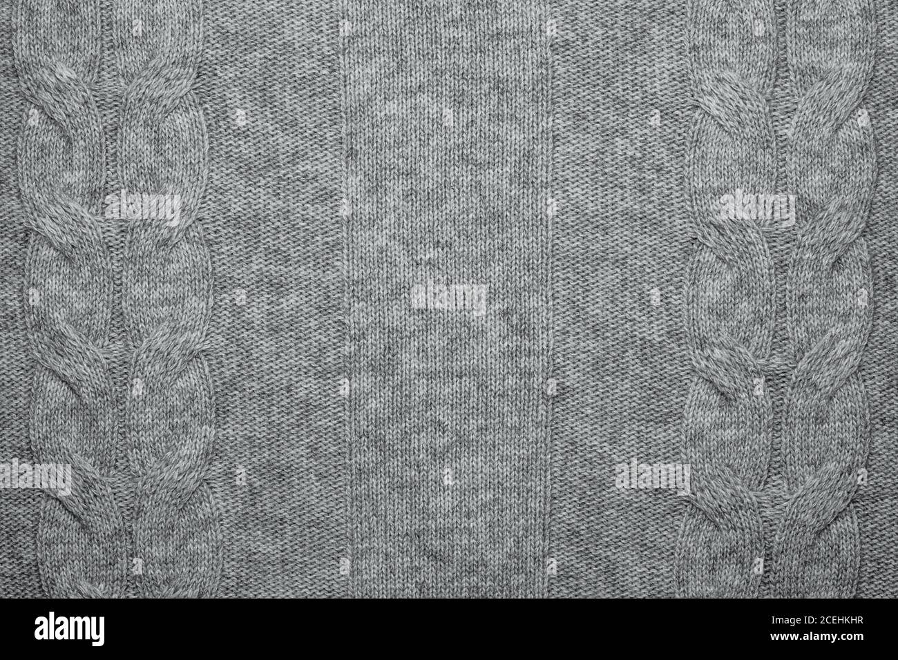 Wool sweater texture close up. Knitted jersey background with a relief pattern. Braids in machine knitting pattern Stock Photo