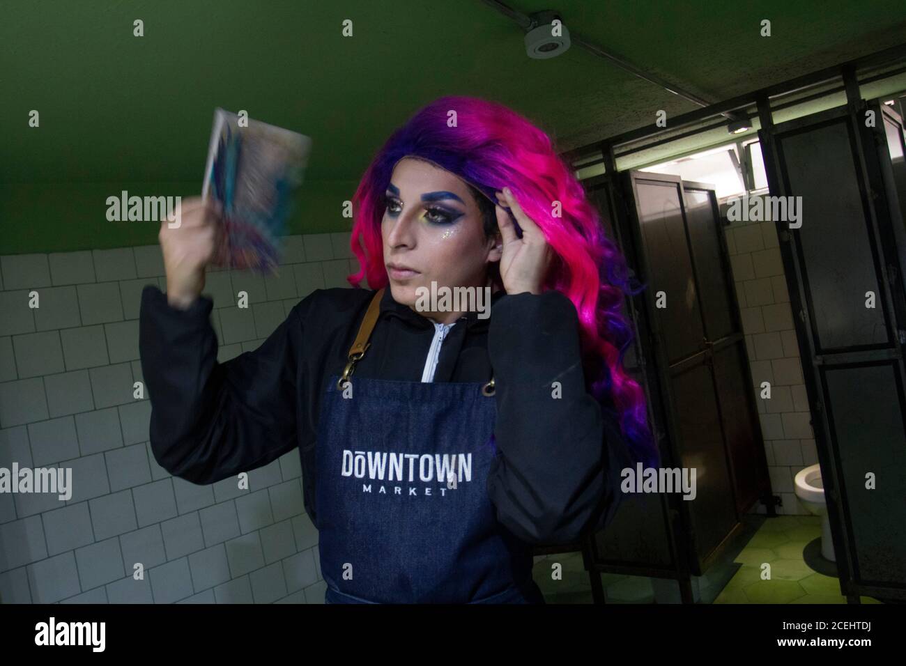 Andrés (a.k.a Uriel The Drag) accomodates his wig prior to start his shift at Downtown Market. He restocks shelves and welcomes customers. In Peru 647,166 people have been infected and 28,788 have died because of Covid-19 as of August 31, 2020. Stock Photo