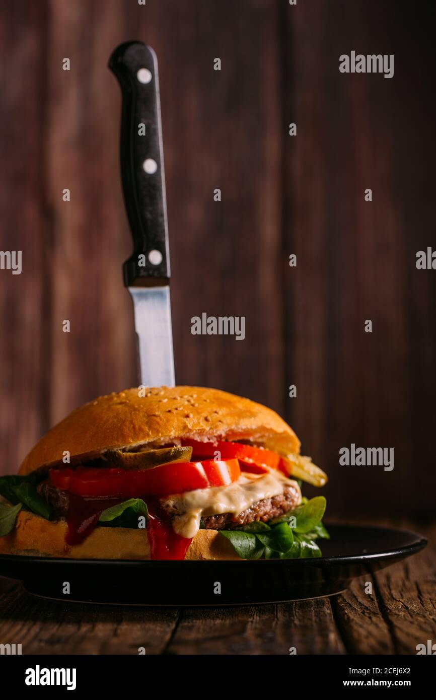 Delicious gourmet burger on dark wooden background Stock Photo