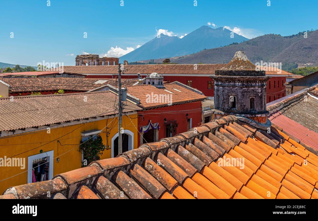 Antigua city skyline seen from a rooftop with volcanic activity and eruptions of the Fuego volcano, Guatemala. Stock Photo