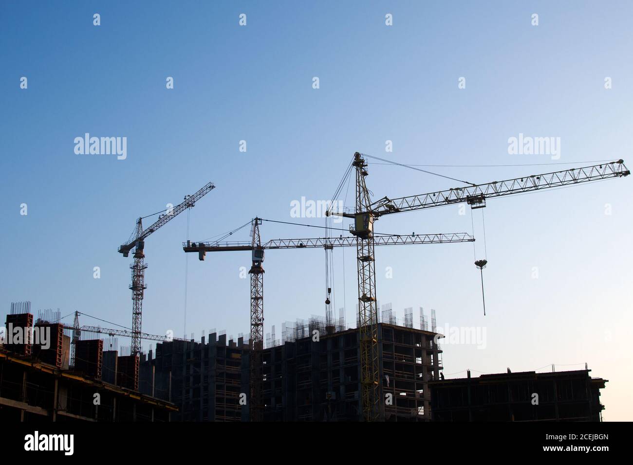 Hydraulic luffing jib tower cranes and workers being poured concrete