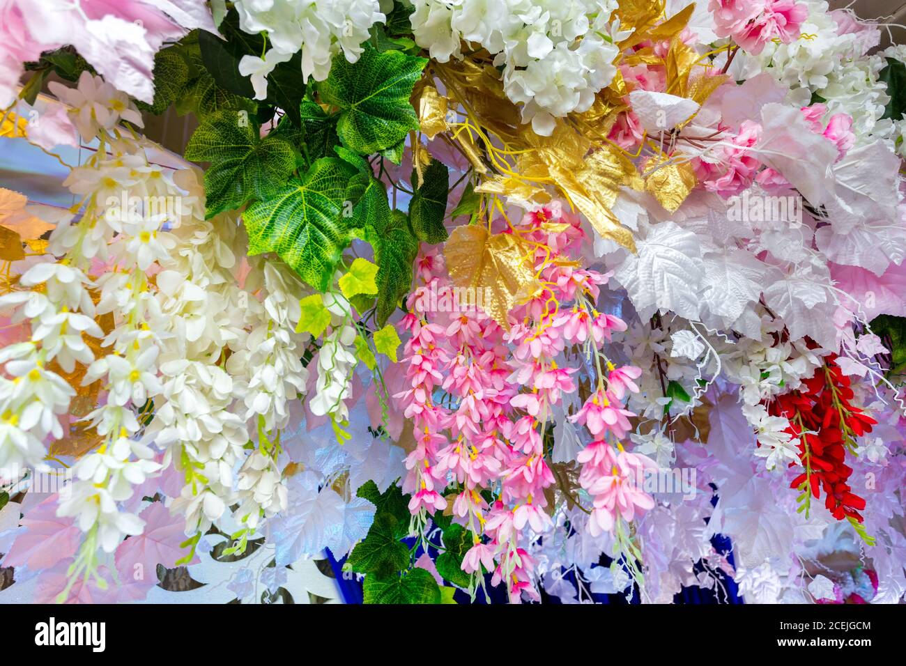 Colorful artificial paper flowers hanging on a stage. wedding ...