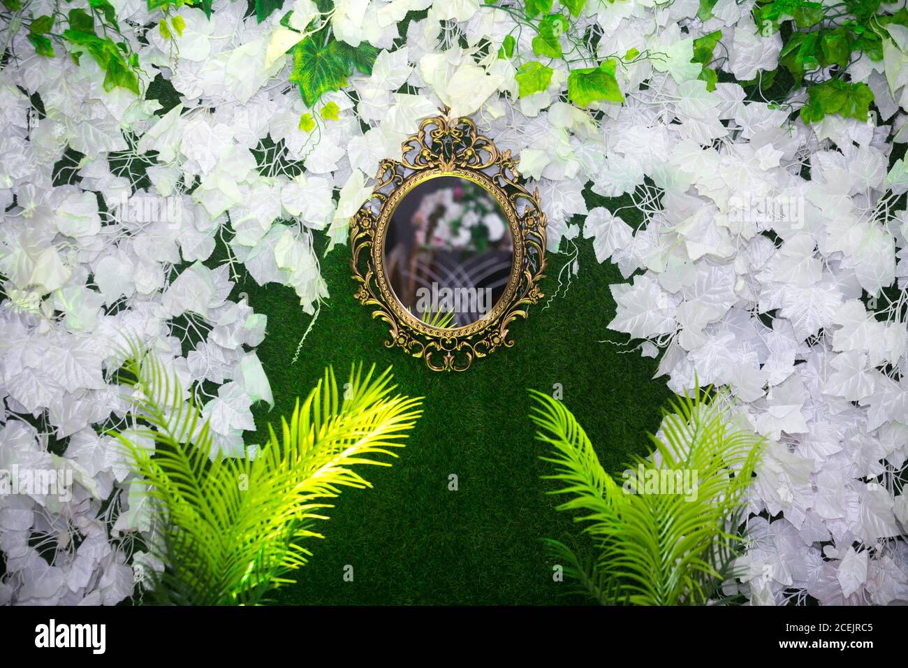 Green artificial grass based wedding stage with handcrafted oval-shaped  vanity wall mirror decoration background. Plastic artificial flower.  Wedding d Stock Photo - Alamy