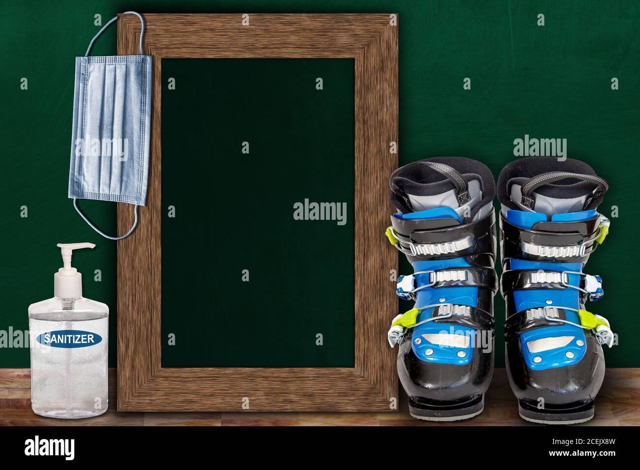 COVID-19 new normal sports concept in a classroom setting showing framed chalkboard with copy space and a pair of ski boots on wooden table. Stock Photo
