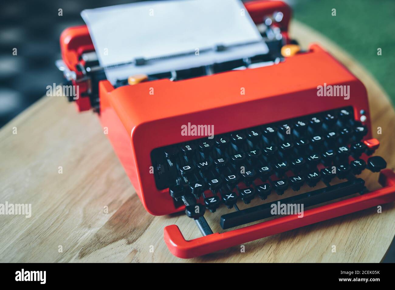 Close-up bright red typewriter on small table with paper sheet inserted Stock Photo