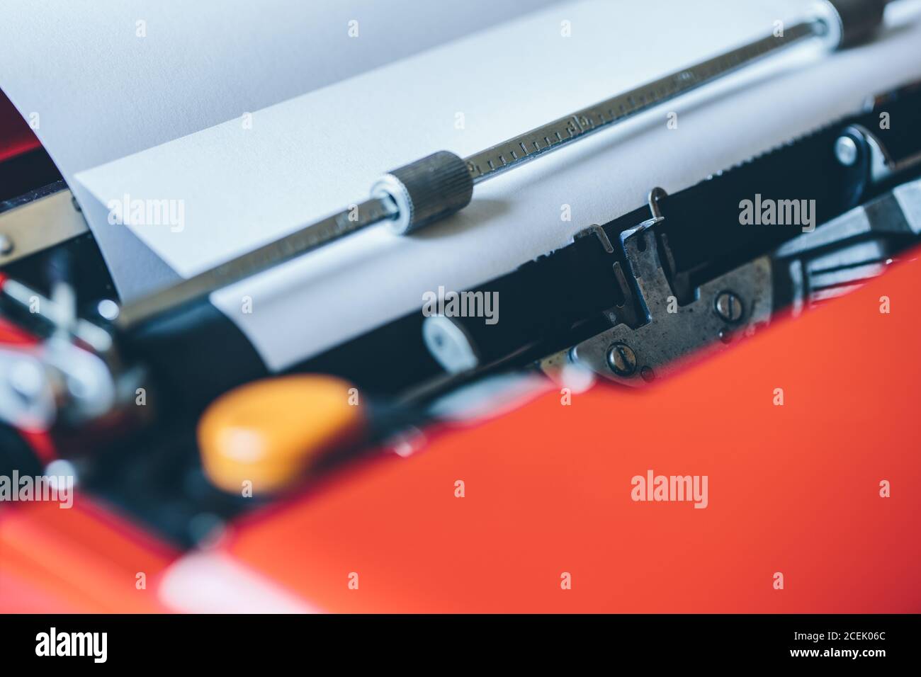 Close-up white blank paper sheet inserted into bright red typewriter Stock Photo