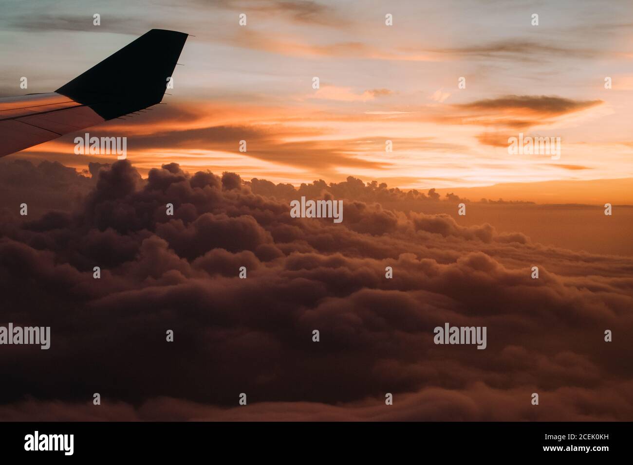 Clouds and plane wing in sunset Stock Photo
