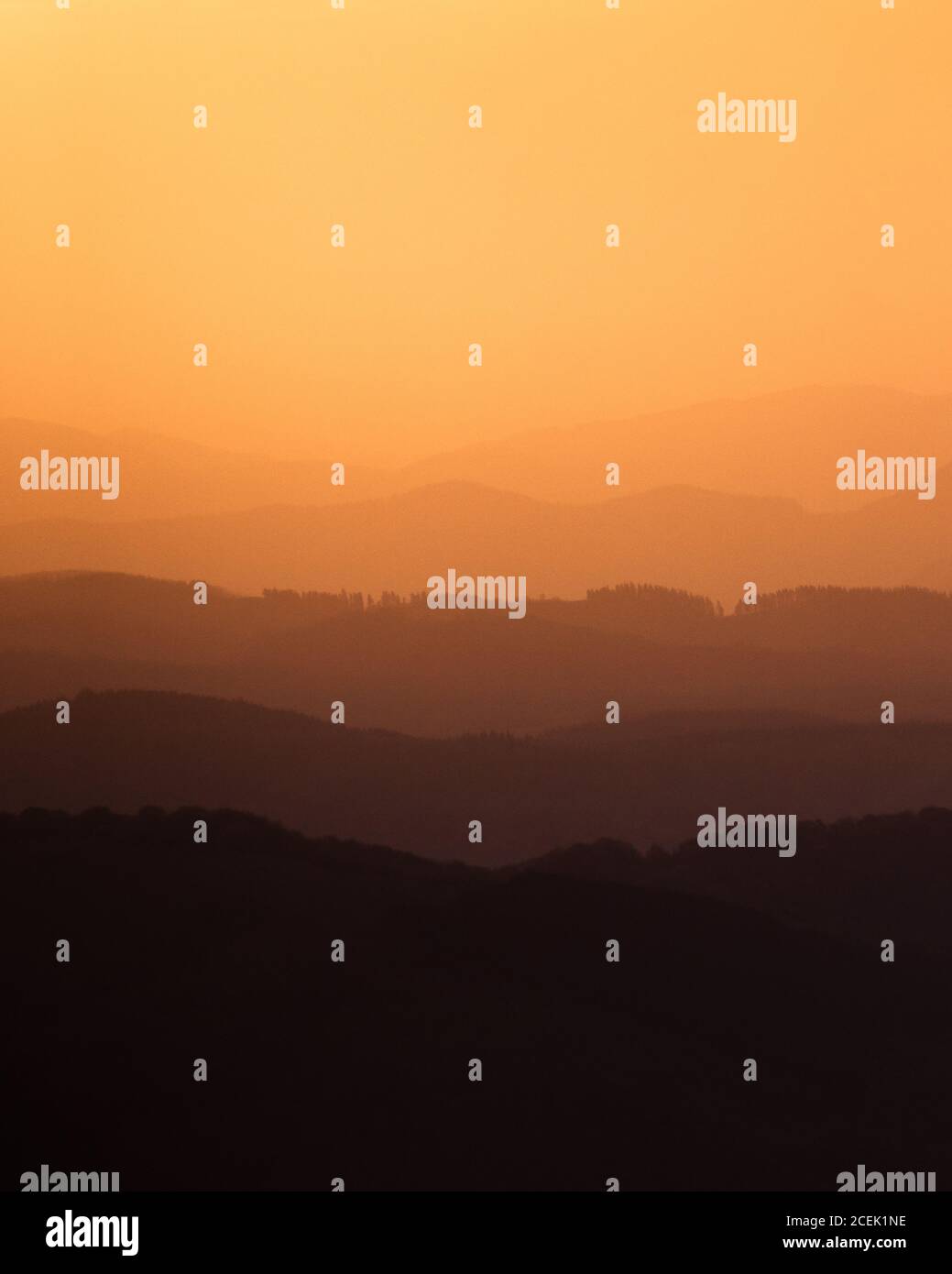Beautiful view of amazing hilly terrain in orange light of setting sun Stock Photo