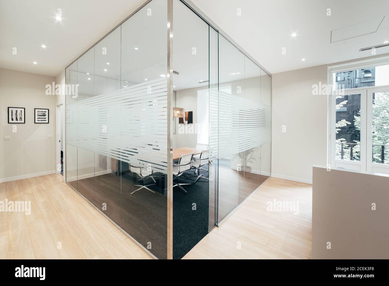 View of table and chairs standing behind glass partition in modern