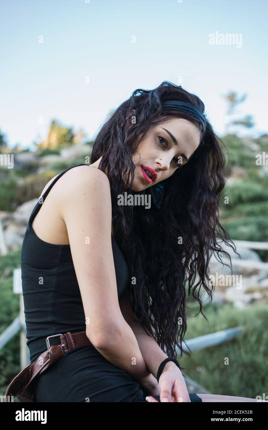 Young Woman sitting on fence and smiling Stock Photo