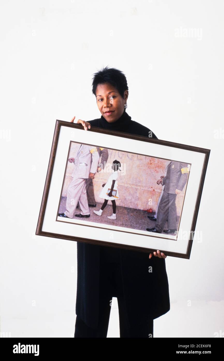 Ruby Bridges holding a print of the Norman Rockwell painting The Problem We All Live With Stock