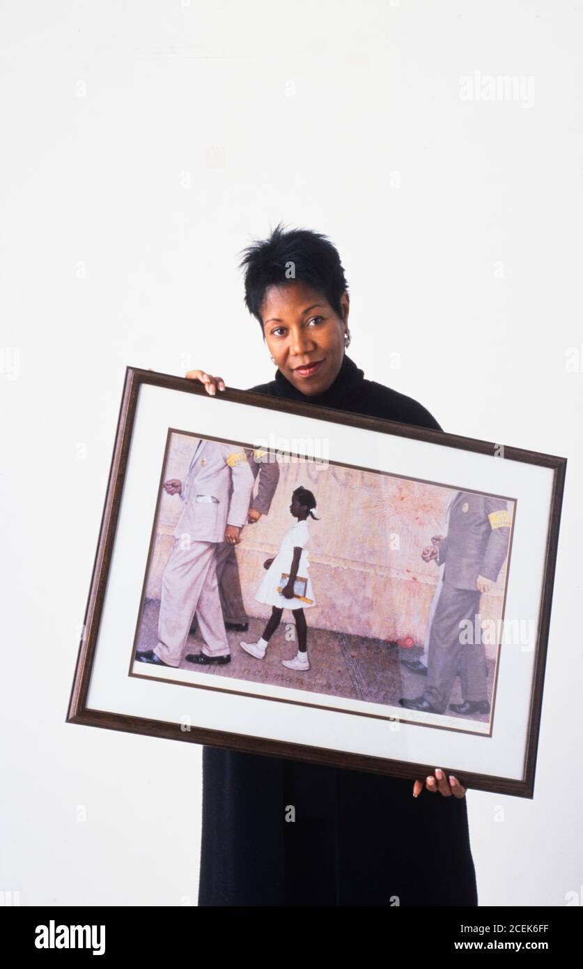 Ruby Bridges holding a print of the Norman Rockwell painting The Problem We All Live With Stock