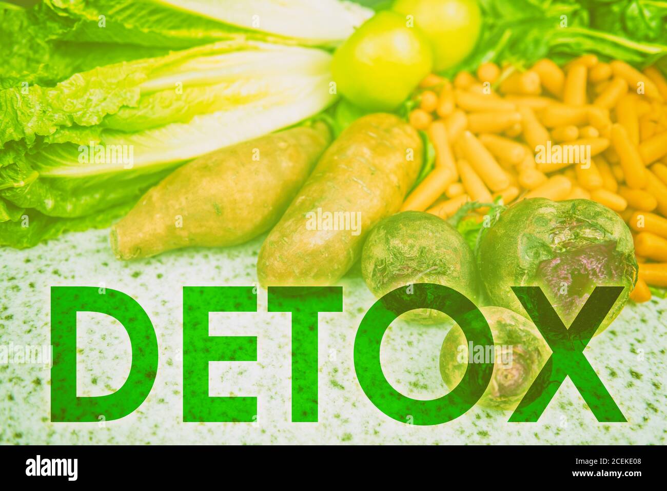 DETOX word title written across uncooked raw vegetables background for eating healthy diet weight loss concept. Green filter over farmer's market Stock Photo