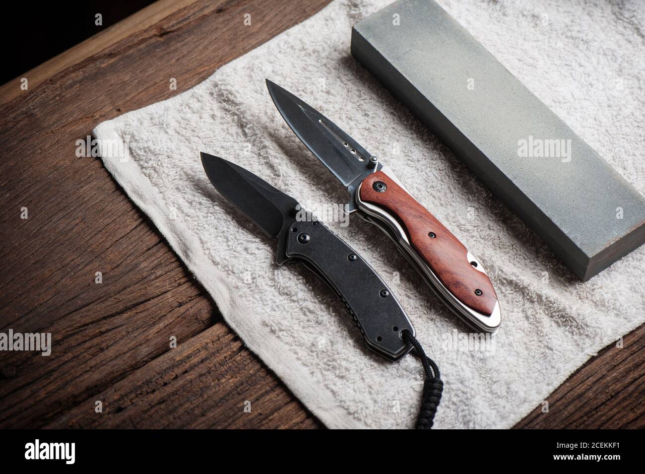 Man sharpening his pocket knife with a whetstone on a rustic wooden table  Stock Photo - Alamy