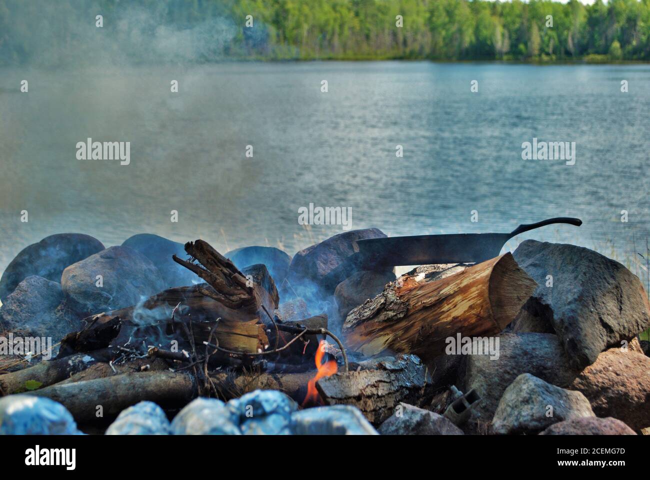 Cooking on a castiron skillet over a camp fire next to the lake Stock