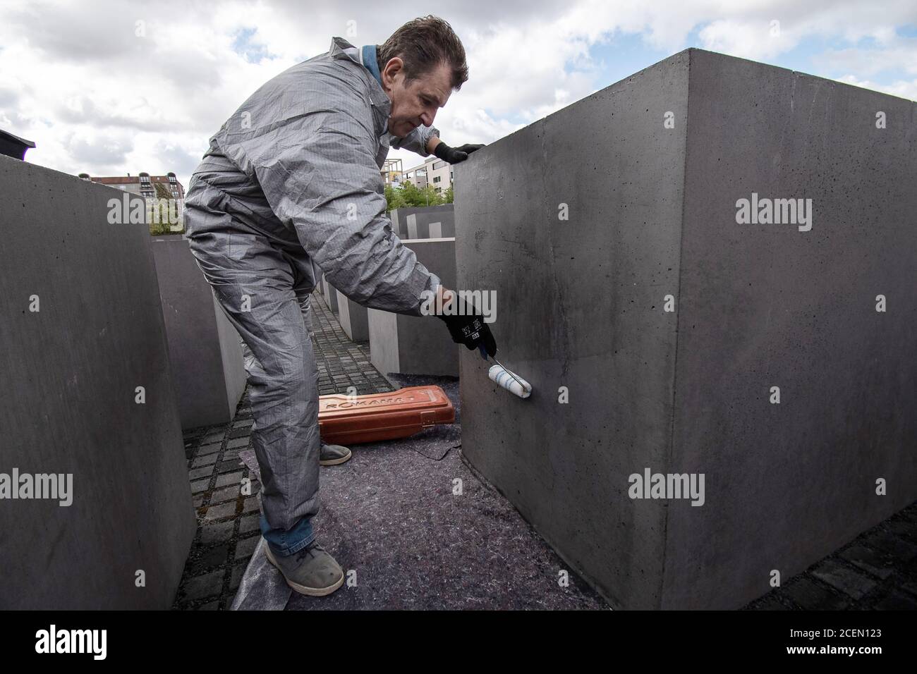 Berlin, Germany. 27th Aug, 2020. Bernd Efinger, managing director of the company EAG from Hanover, applies a pattern of graffiti and surface protection on a stele of the Memorial to the Murdered Jews of Europe, or Holocaust Memorial for short. At the Berlin Holocaust Memorial, a restoration method has been tested. This involves damage to the concrete steles, which have been a problem for years. (to 'Test restoration at the Berlin Holocaust Memorial') Credit: Paul Zinken/dpa-Zentralbild/dpa/Alamy Live News Stock Photo