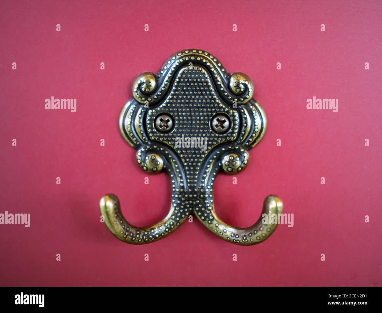 Bronze rope hook for clothes on a burgundy wall Stock Photo Alamy
