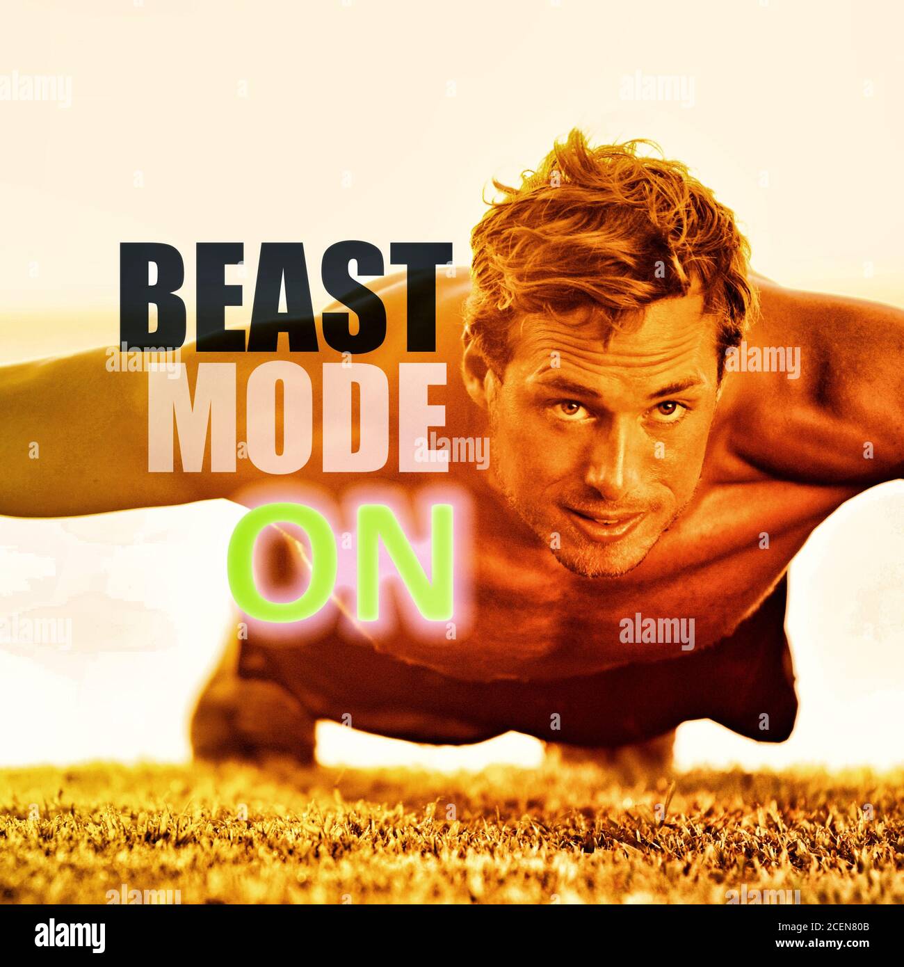 Fitness man working out exercise at gym inspirational quotes. BEAST MODE ON motivational quote written over athlete training push ups on grass, focus Stock Photo