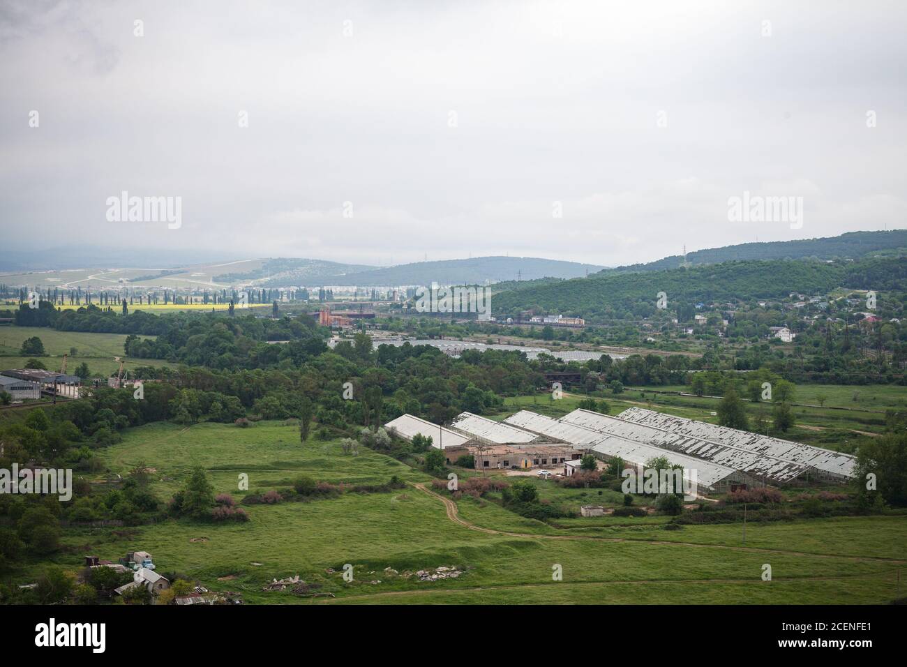 Crimean landscape with mountains and abandoned greenhouses at cloudy summer day. Inkerman, Sevastopol Stock Photo